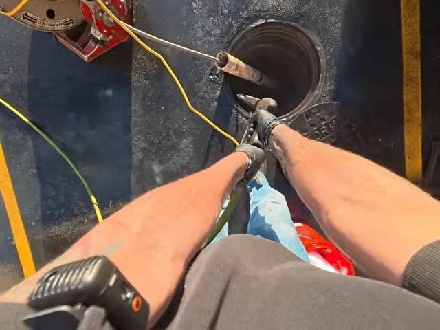 Pulling drain cable from commercial cleanout, part of everyday plumbing calls around Austell, GA.